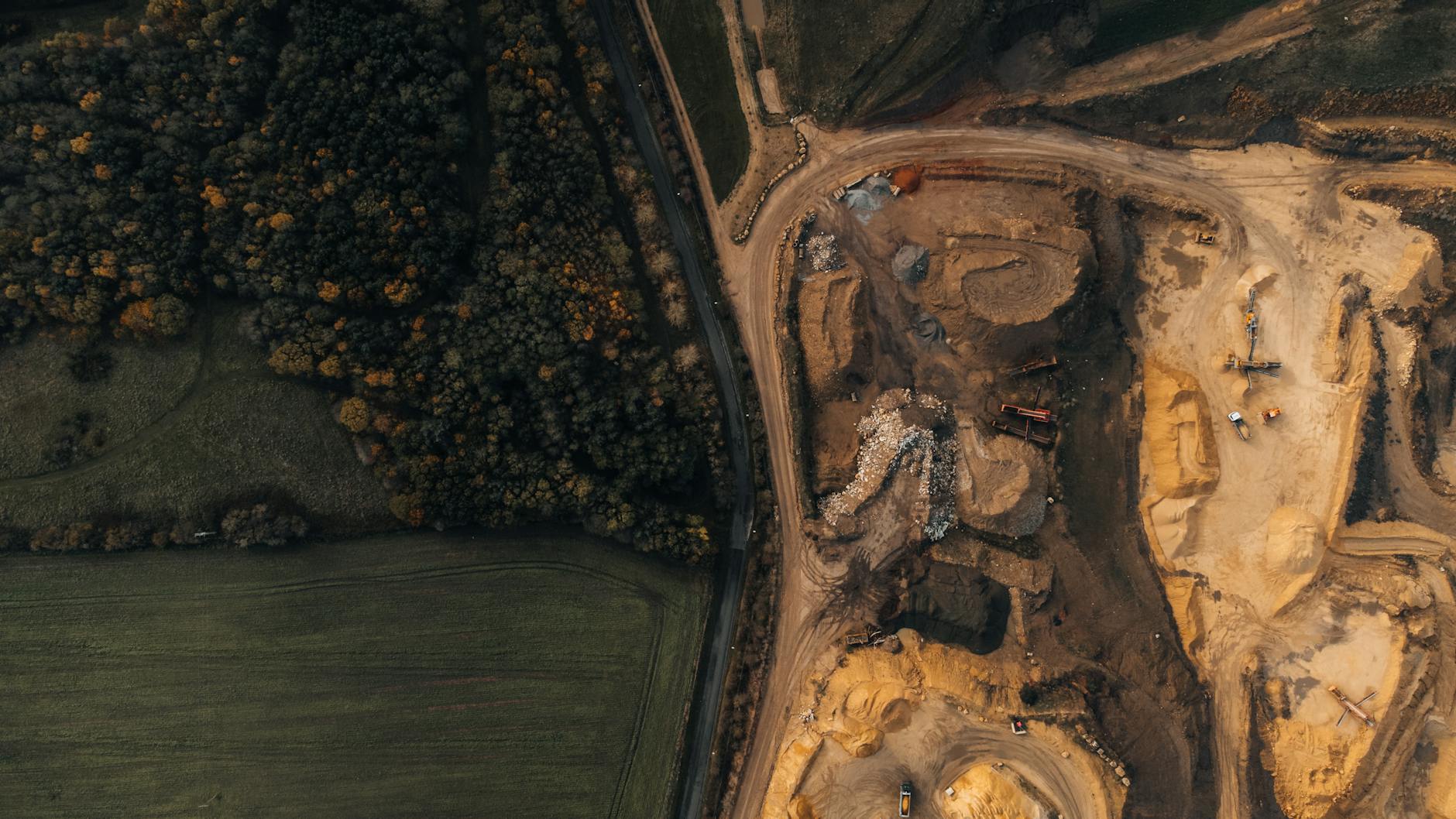 An industrial mining operation site next to a forest